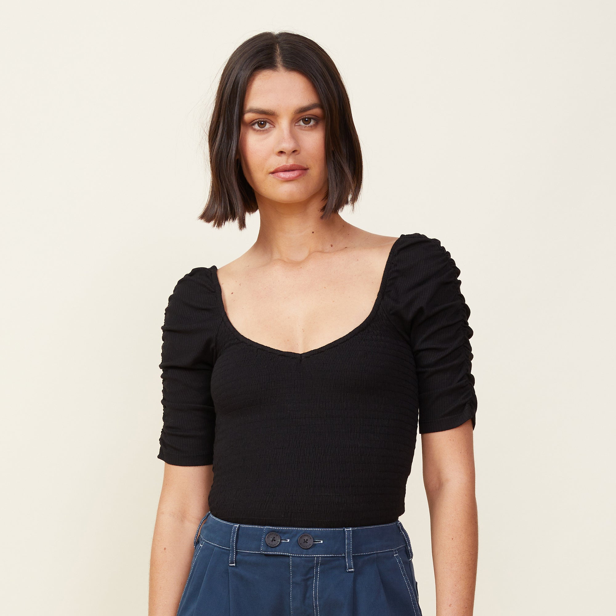 Front view of model wearing the rib smocked top in black.