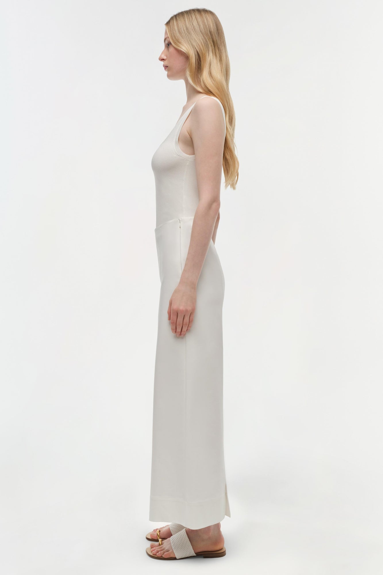 Woman wearing cream cotton cropped pants with a sleeveless top, shown in side profile.