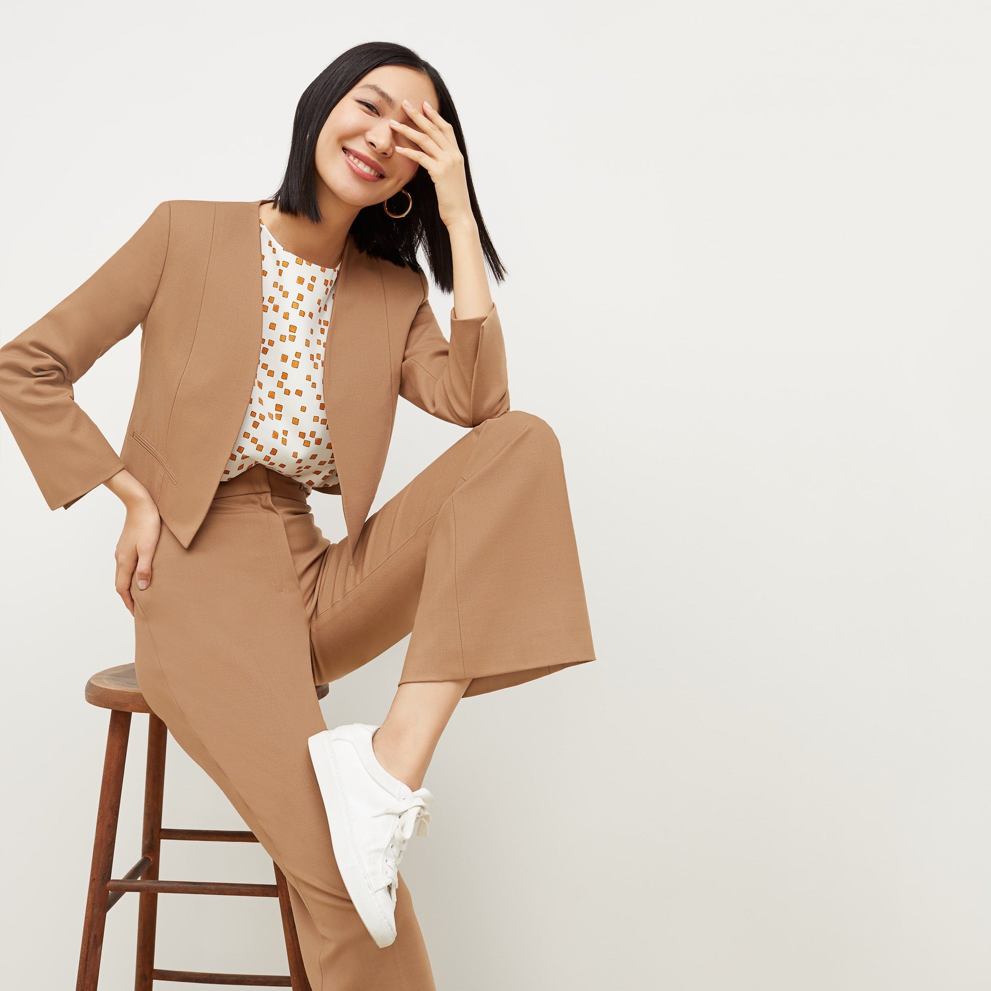 Front image of a woman standing wearing the Neale jacket in camel | Exclude