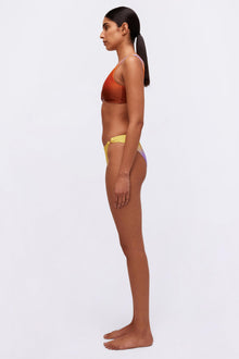 Yellow and purple colorblock bikini bottom with side tie details, shown in profile view.