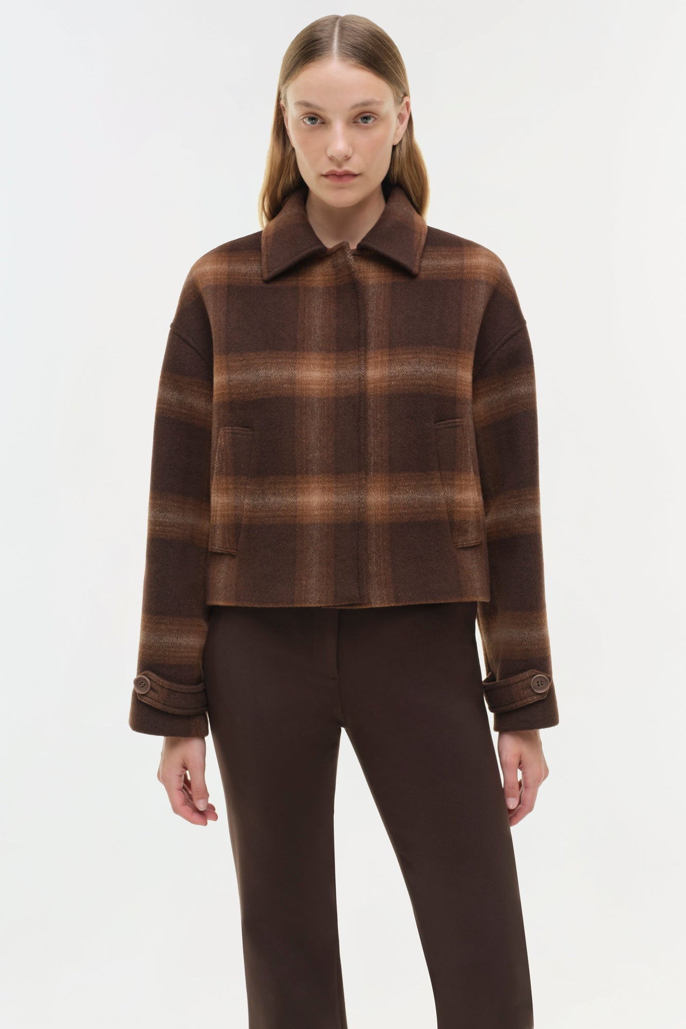 Brown plaid wool jacket with collar and patch pockets, worn with solid brown trousers.