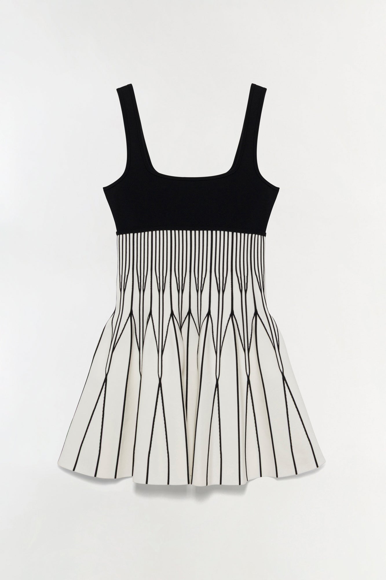 Black and white knit mini dress with solid black bodice and pleated skirt with vertical stripe pattern.
