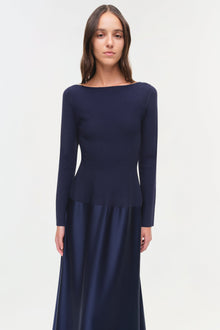 Navy long-sleeve gown with round neckline and satin skirt panel at hip.