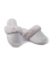 A pair of Womens Faux Fur Trim Slippers in light gray by Petite Plume, showcasing plush comfort with soft fur trim, is displayed on a white background. One slipper stands upright while the other rests elegantly on its side.