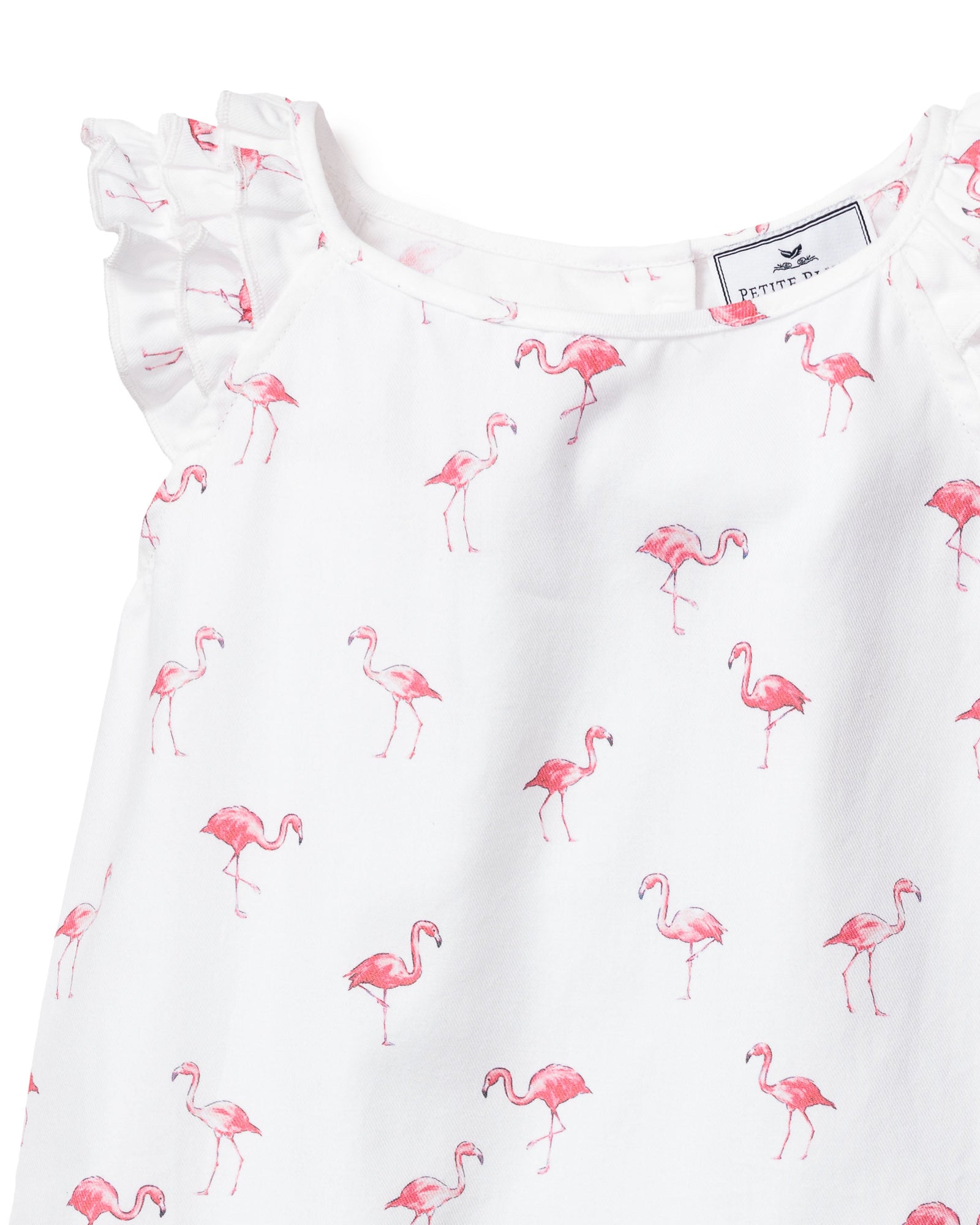 The Girls Twill Amelie Short Set by Petite Plume features a white sleeveless pajama dress with ruffled shoulders and charming small pink flamingos, offering a whimsical touch of comfort.