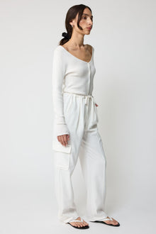 Woman wearing a white outfit on a plain background