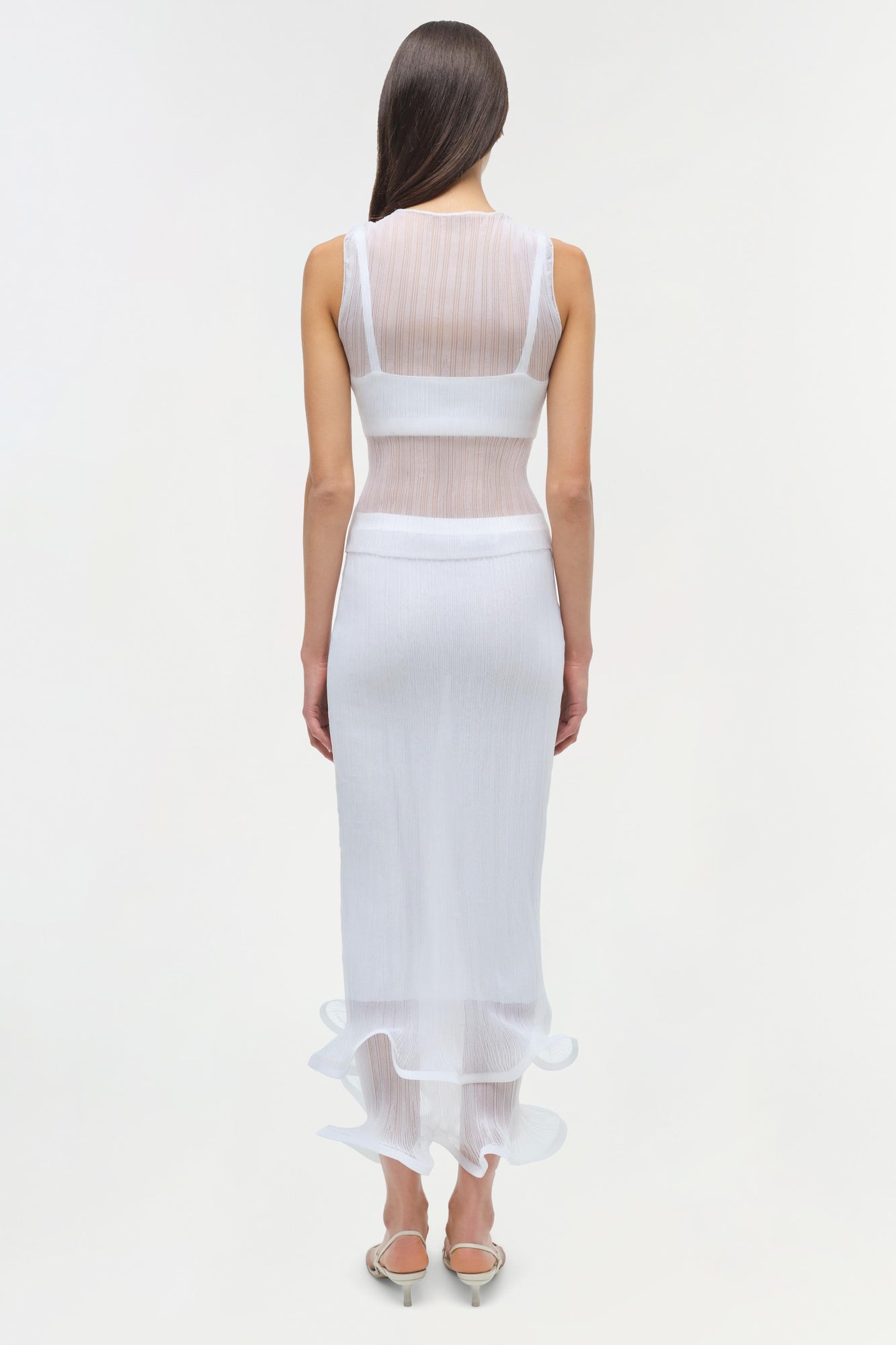 White ribbed sleeveless tank top with sheer mesh back panel, shown on model from behind.