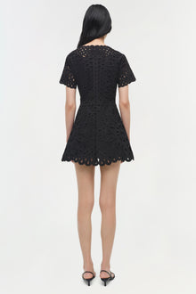 Black mini dress with eyelet embroidery, short sleeves, and scalloped hem, shown from back.