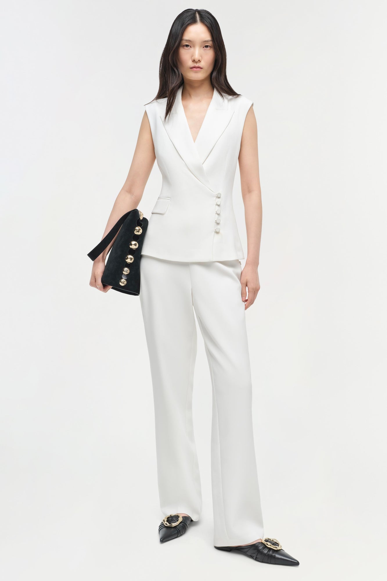 White straight leg trousers with a high waist and flat front, worn with a sleeveless white blazer.