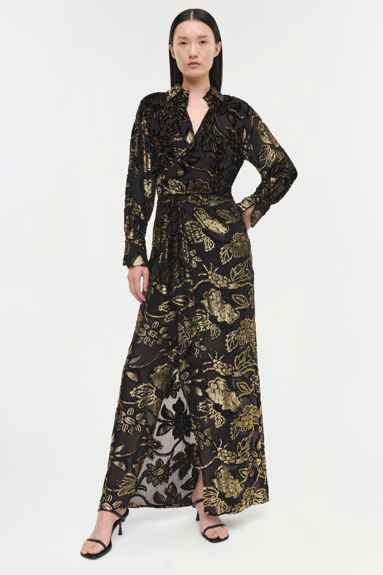 Black wrap gown with gold floral print, long sleeves, and maxi length with side slit.