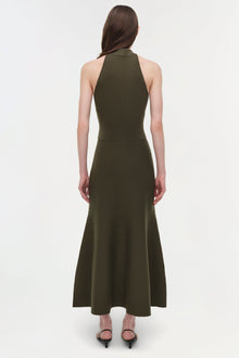 Woman wearing olive green wool midi skirt with matching halter top, back view.