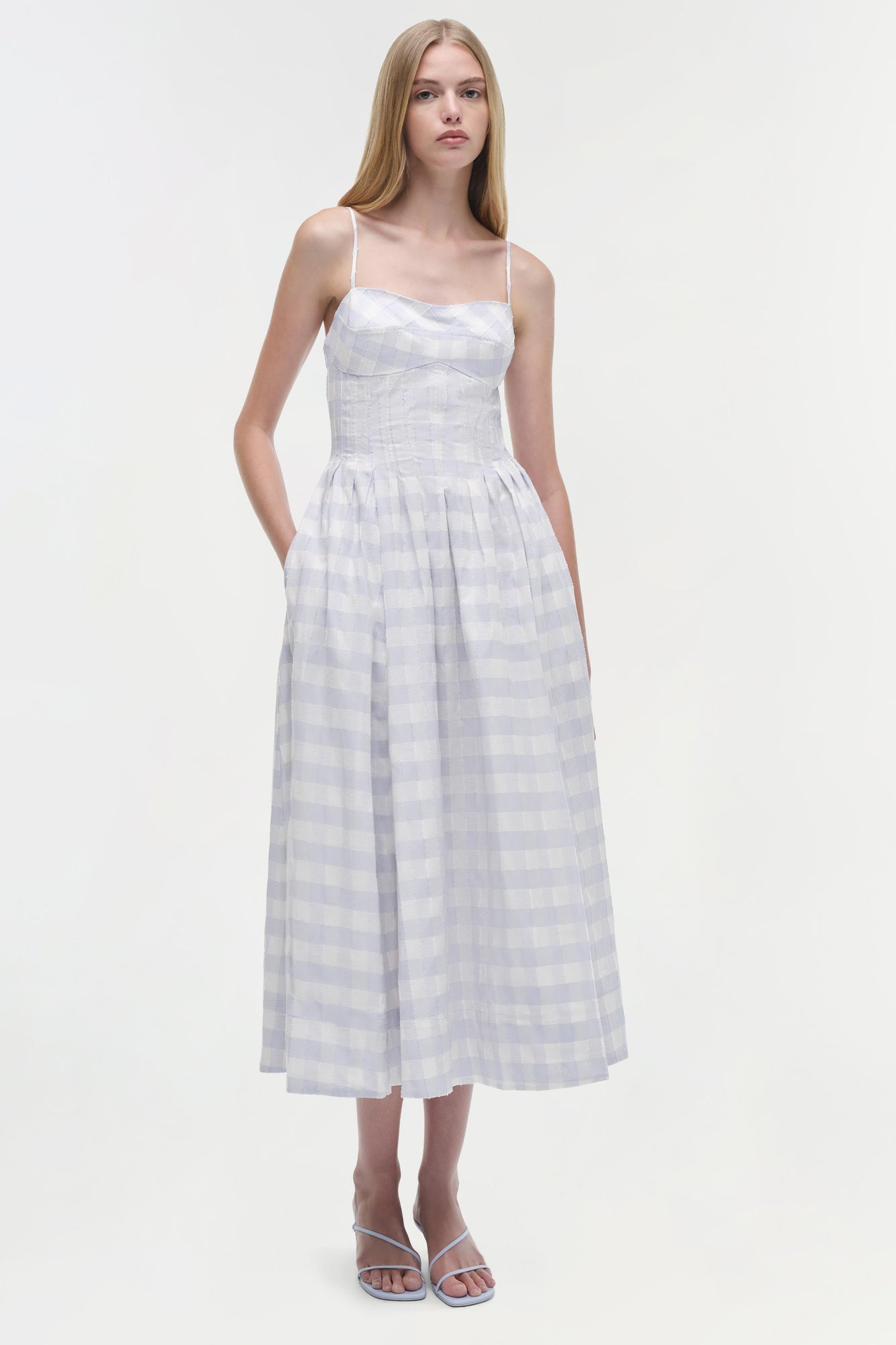 White and lavender gingham cotton midi dress with thin straps, fitted bodice, and full skirt on model.