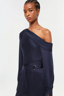 Woman wearing navy Carolina Pant with off-shoulder top and belt detail at waist.