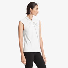 Side image of a woman standing wearing the Walters top knit crepe in Ivory