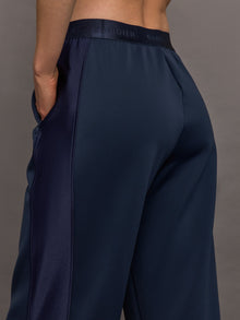 Model wears navy wide leg pants with an elastic waistband. 