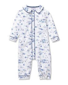 The Baby's Twill Cambridge Romper in Chalet Toile is a white long-sleeve, full-length onesie with blue alpine scene prints and blue piping on the collar, cuffs, and front placket.