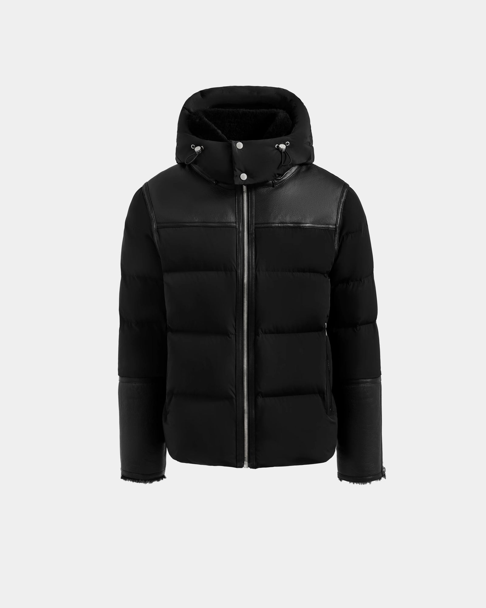 The Rudsak DAVID - M125508 Black puffer jacket is winter-ready with a hood, front zipper closure, and leather-like accents on the shoulders, upper sleeves, and cuffs, shown on a light gray background.
