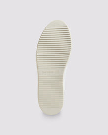 Bottom angle of white, grey and green sneakers