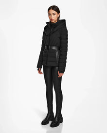 A woman wearing the Rudsak ALISA - L124506 Black quilted down puffer with a vegan leather belt.