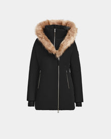 The Rudsak AURORE - L123561 Black/Natural parka features a weather-resistant design, a large natural fur-trimmed hood, front zipper, and two zippered side pockets, shown against a plain white background.