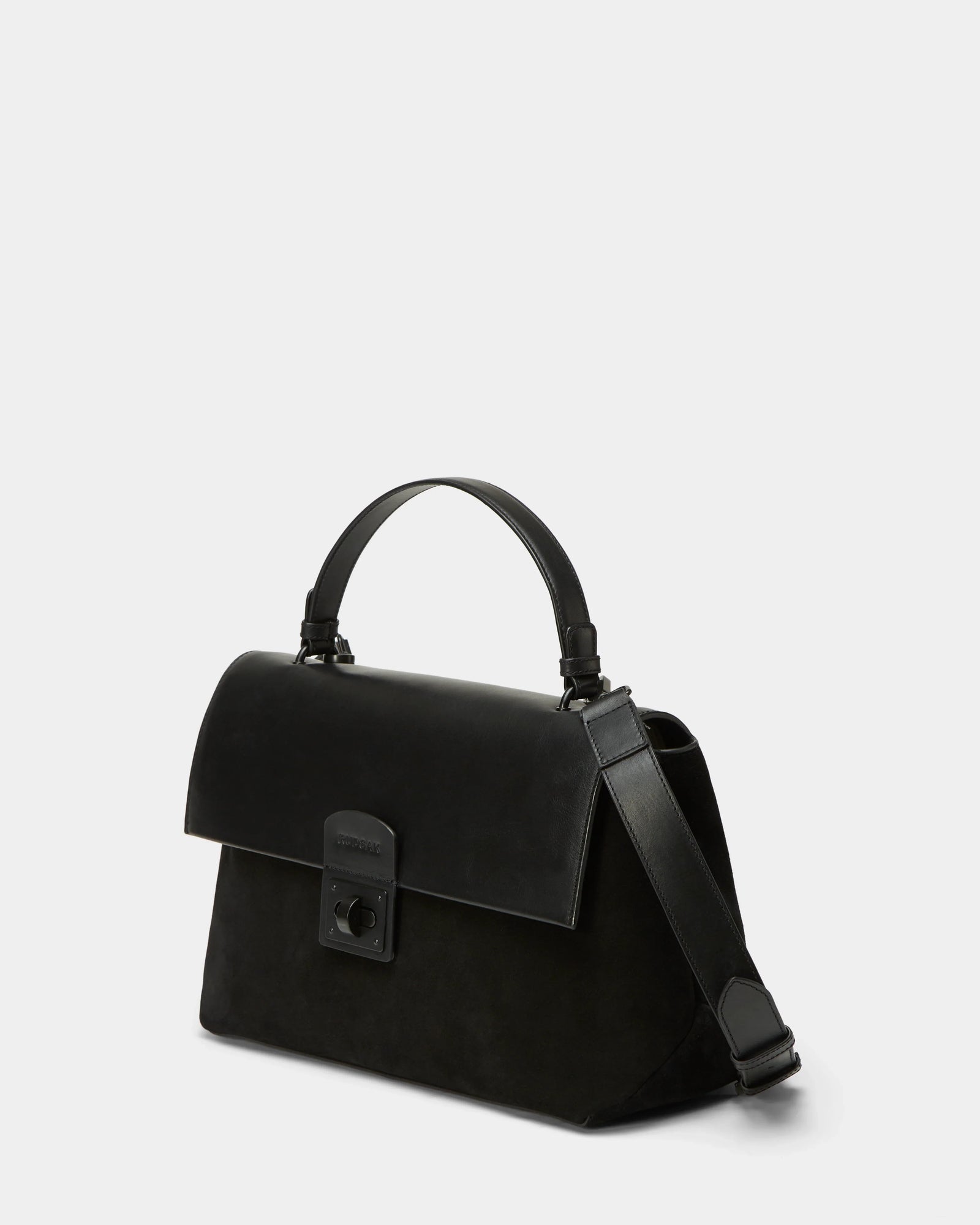 The Rudsak ESMA - 8324519 Black handbag features suede and leather, a top handle, removable wide adjustable strap, and a front flap with rectangular clasp, shown against a plain light background.