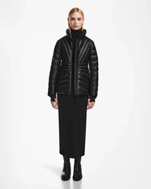 A woman in a sleek black coat, styled in the Rudsak HANNA X - 8123558—a luxury down jacket that elevates any look.
