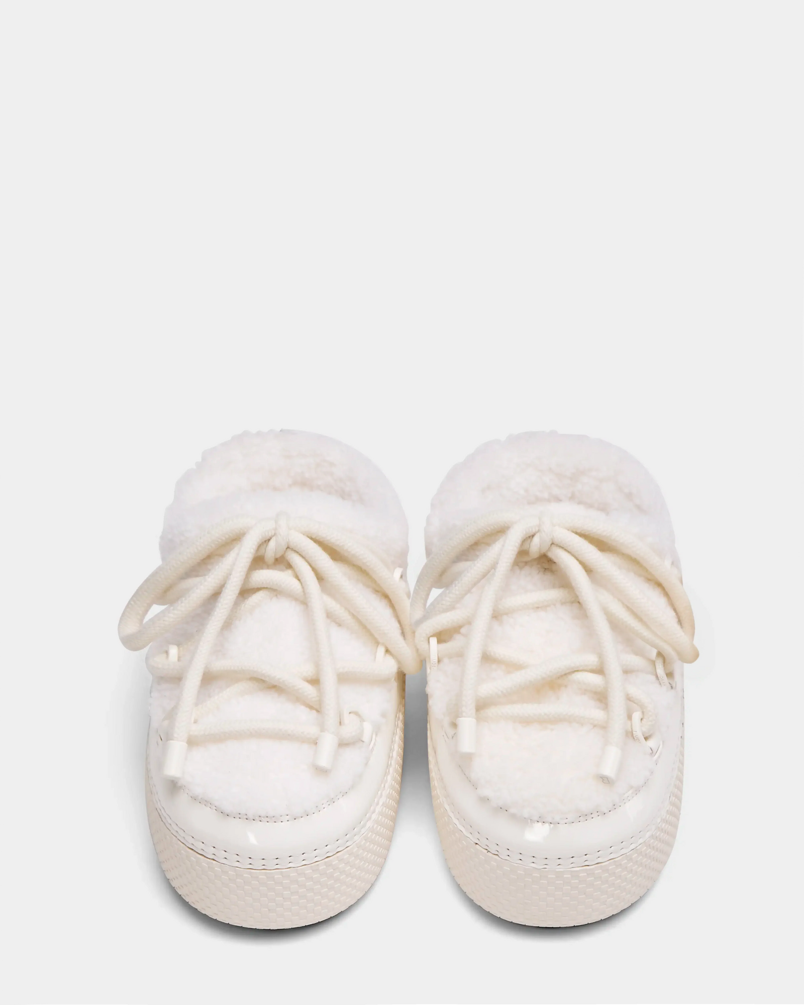 A pair of HARRIET - 8224519 Iceland baby shoes by Rudsak, soft and white with fluffy lining and white laces, resembling mini moon boots, are placed side by side on a plain light background.