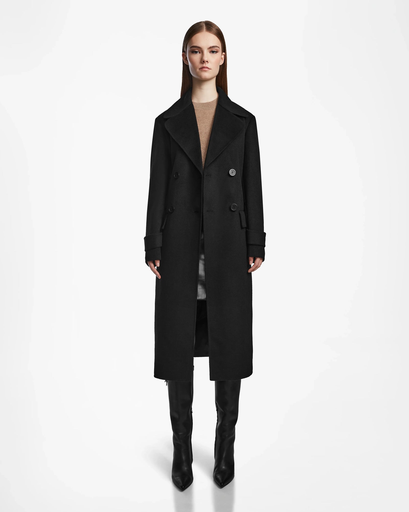 A woman faces forward wearing the IVE - L124560 Black womens wool blend long coat by Rudsak, paired with a brown top, gray skirt, and black knee-high boots against a plain white background.