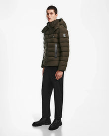A man confidently showcases the NAVAN - 6124551 Army light down puffer by Rudsak, highlighting its warmth and modern design.