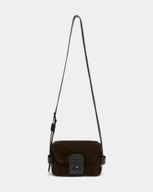 The Rudsak OFILIA S - 8324521 Espresso is a dark brown suede crossbody bag with a long adjustable strap, front flap, and black rectangular clasp, shown against a plain light gray background.