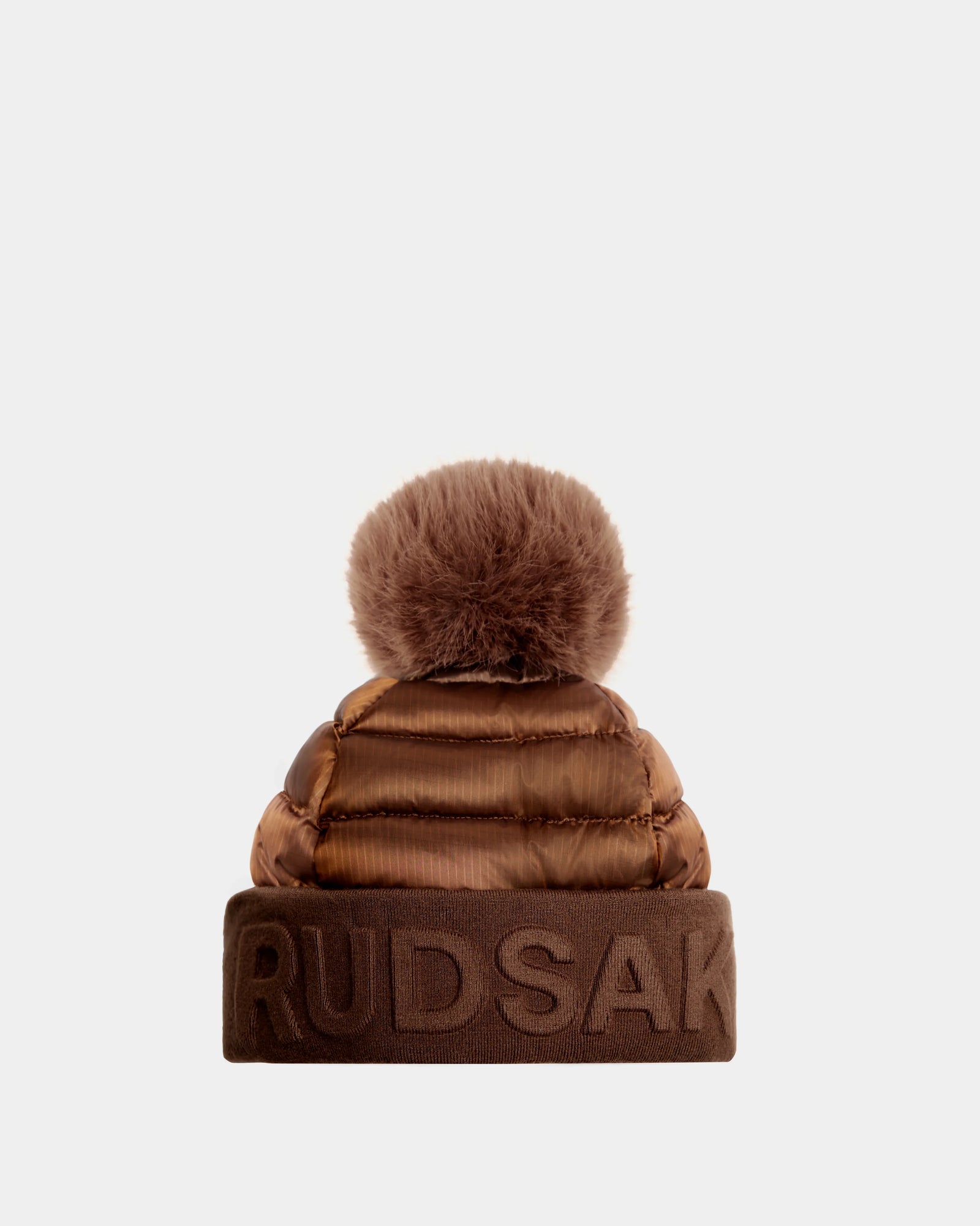Rudsaks OLYA - 8422504 in Antique Bronze is a womens brown puffer winter hat with a wide cuff embossed with RUDSAK and topped with a large, fluffy fur pompom.