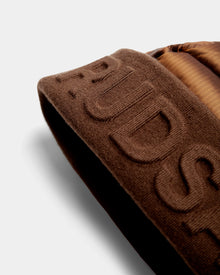 Close-up of the Rudsak OLYA - 8422504 Antique Bronze, showing brown knit fabric with raised embroidery and a section of shiny, quilted RDS-certified down, set against a light background.