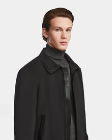 A young man with short, slicked-back brown hair wears the Rudsak REECE - 6124592 Black water-resistant bomber jacket with a shearling collar over a gray turtleneck, standing against a plain white background, looking slightly to the side.