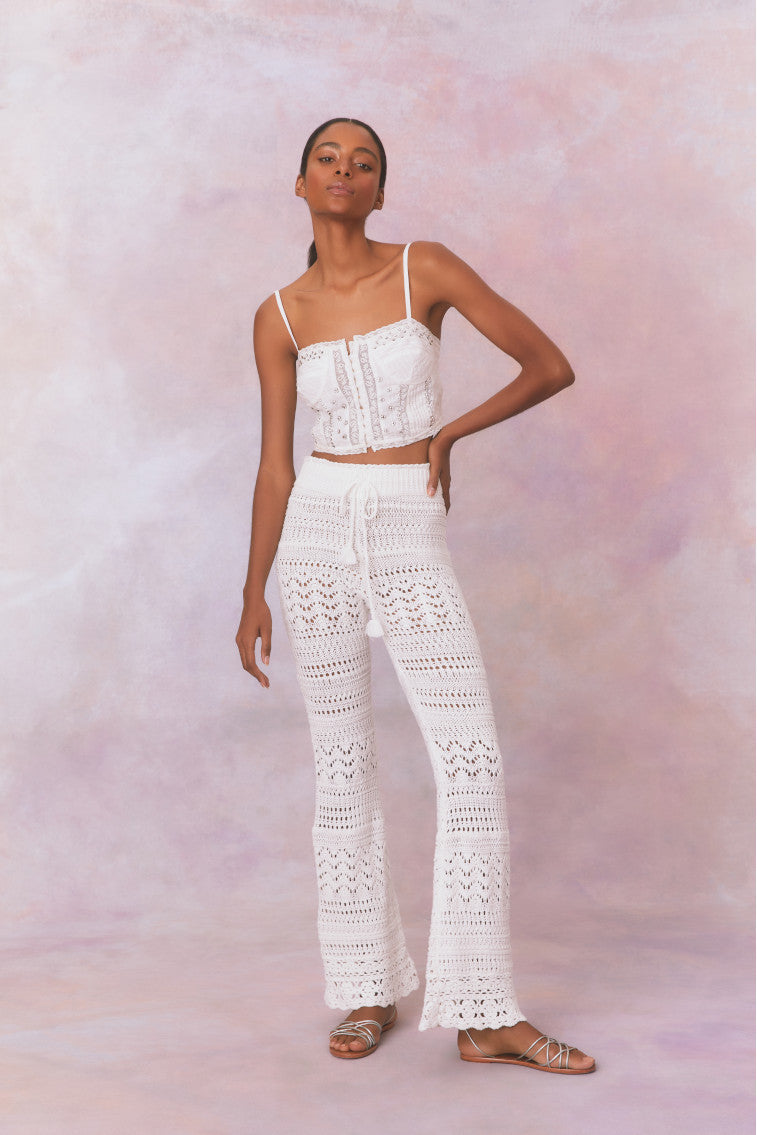 White cotton pointelle crochet floral flare pants with a self tie detail at center front on the double ribbed waistband.