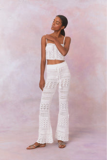 White cotton pointelle crochet floral flare pants with a self tie detail at center front on the double ribbed waistband.