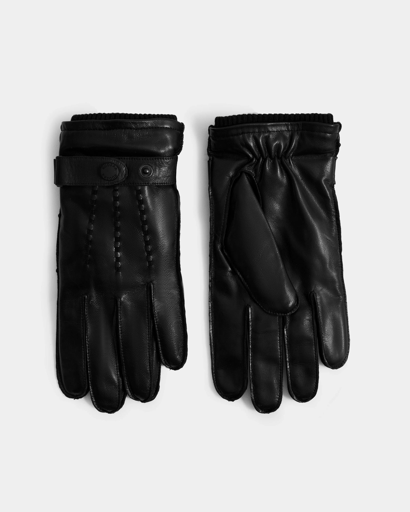 The Rudsak BORIS - M425001 Black men’s leather gloves, with button details, ribbed cuffs, and a soft wool-cashmere lining, are shown side by side on a plain white background.