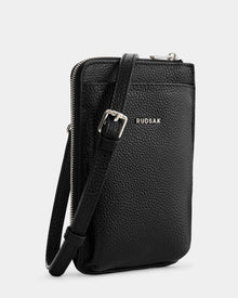 The Rudsak CELYN - L325514 Black is a women's black pebbled leather crossbody bag with a slim rectangular shape, silver buckle, zipper closure, adjustable strap, and Rudsak logo on the front.