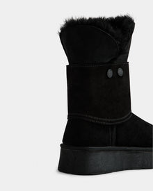 A close-up of the Rudsak INESA - L225026 Black women’s suede platform boot with lace-up front, black fur lining, decorative buttons, and visible stitching, shown on a plain white background.