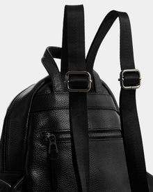 Close-up of the Rudsak KATTY - L325014 Black women’s mini backpack in black pebbled leather, featuring adjustable shoulder straps, metal buckles, a zippered front pocket, and textured material.