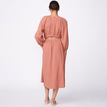 Back view of model wearing the gauze open back dress in faded rust.