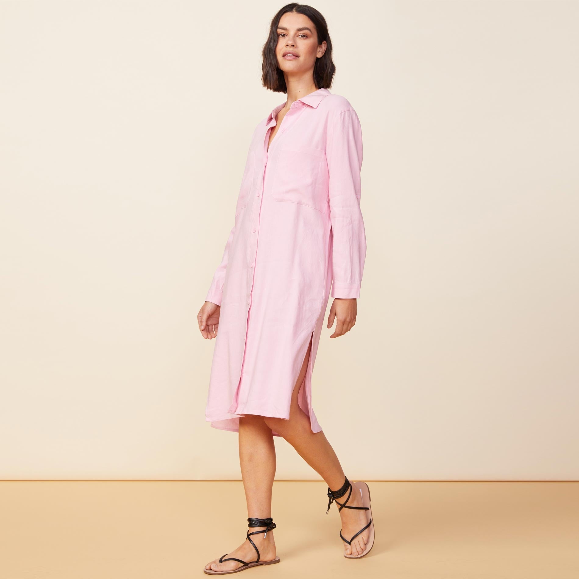 Side view of model wearing the linen shirt dress in bubblegum.