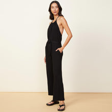 Side view of model wearing the supersoft halter jumpsuit in black.