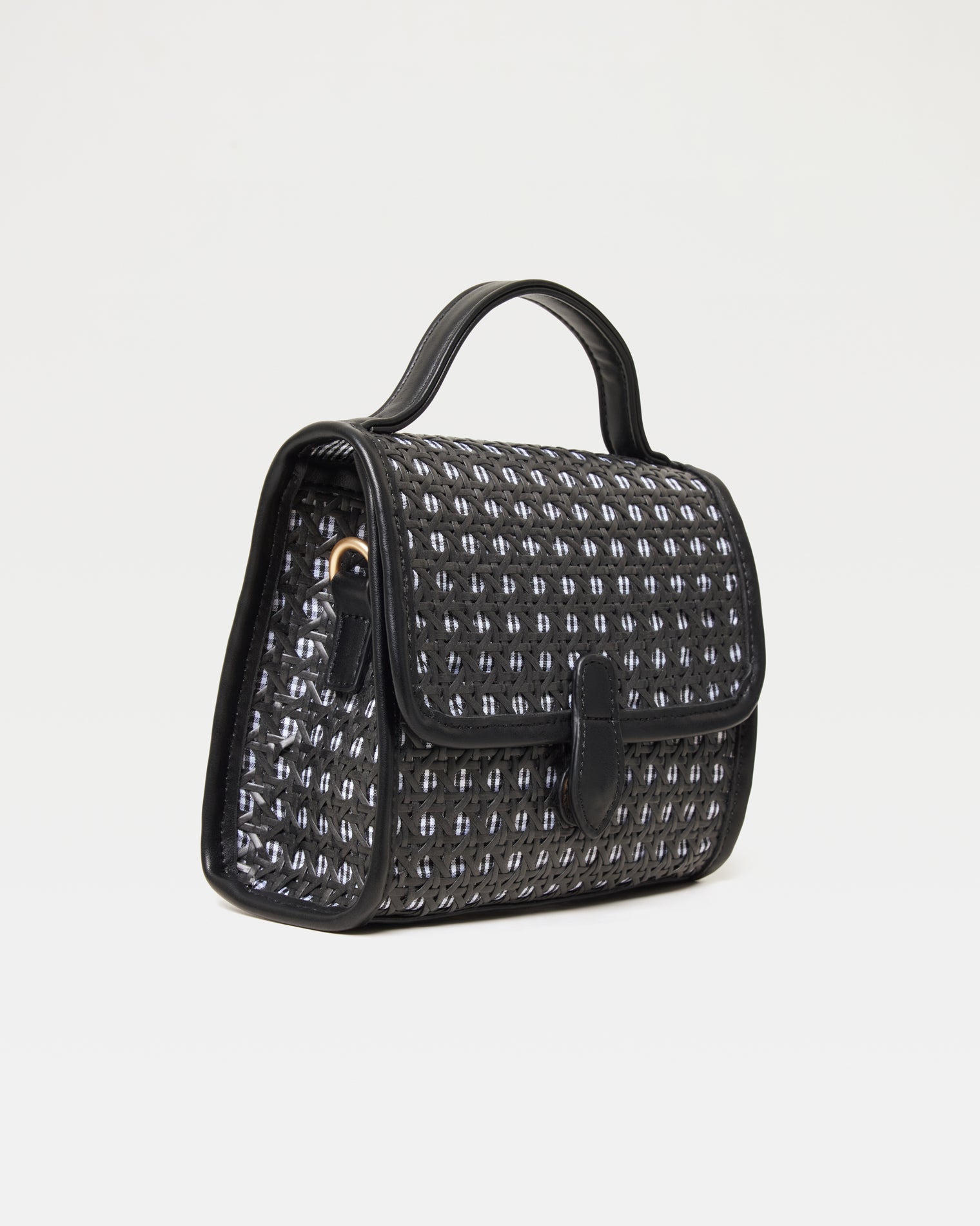 Side view of the Amelia Bag in black showing the woven texture and gold crossbody strap ring.