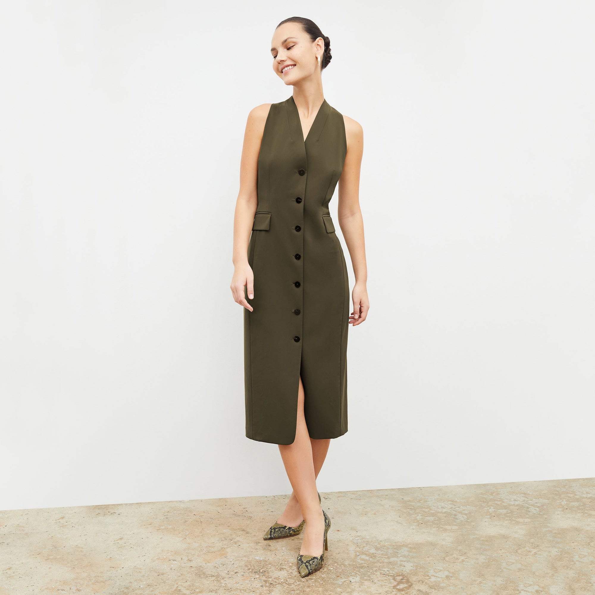 Front image of a woman wearing the Cassandra dress in origamitech in olive | Lead