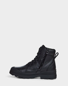 The Rudsak ARTUR - M223501 Black men's ankle boot, made of weather-treated black leather with a rugged sole, lace-up front, side zipper, and back pull tab, is shown in profile against a plain white background.