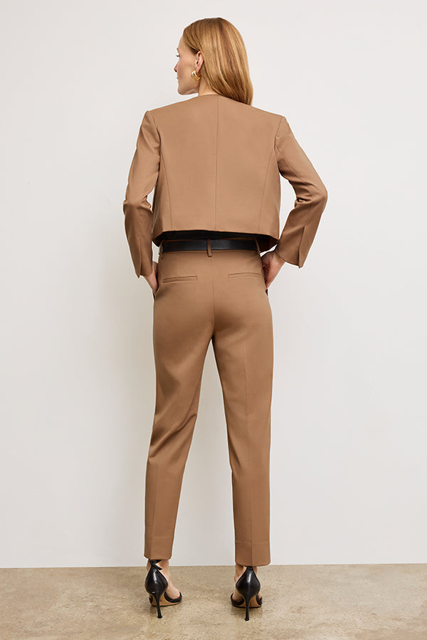 back image of a woman standing wearing the Neale jacket in camel | Exclude