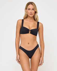 front view of woman wearing a black bikini against a white background