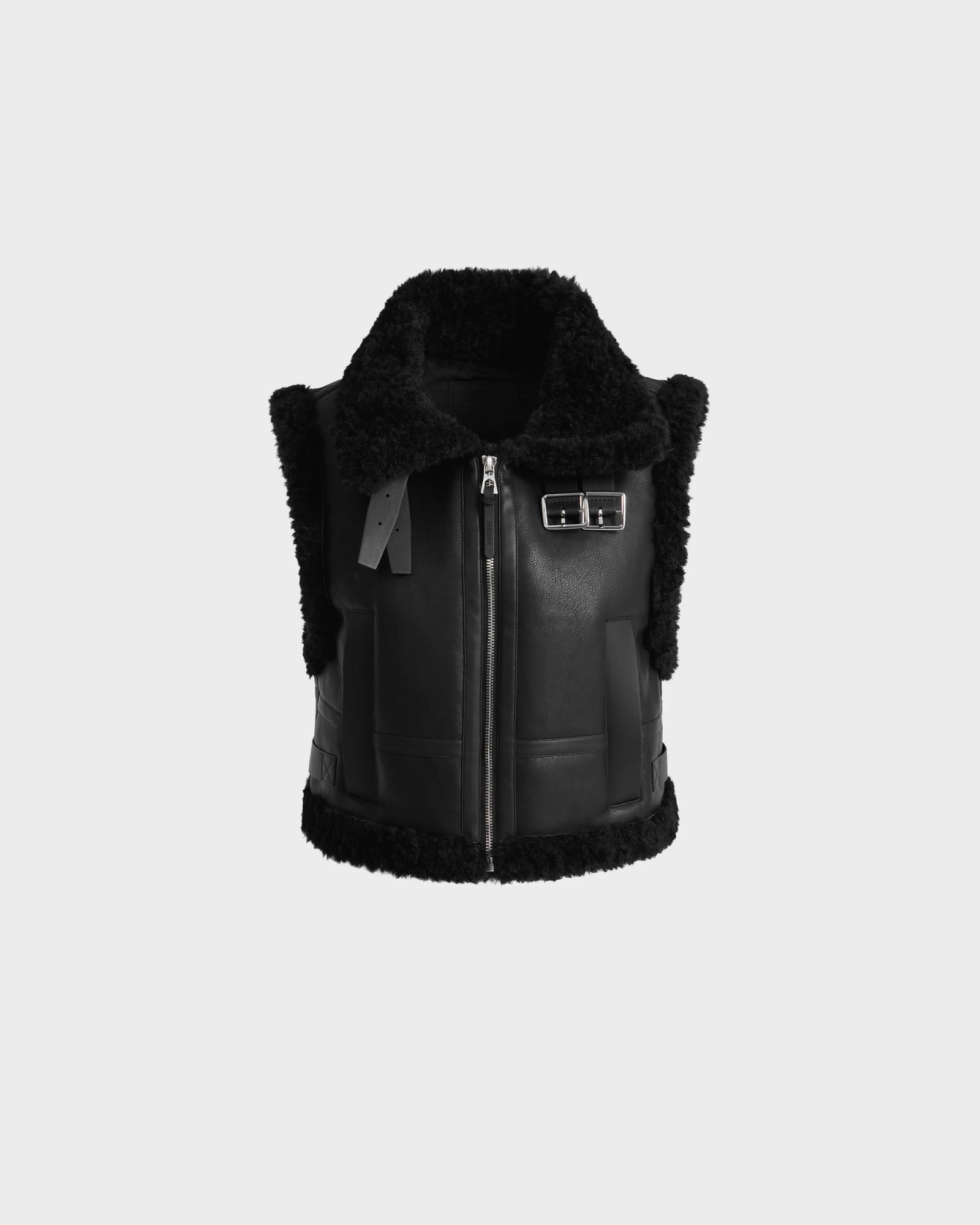 The Rudsak PAISLEY - L125516 Black women's cropped vest features a front zipper, wide collar, side buckle detail, and faux shearling trim, shown against a plain light gray background.