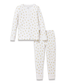 A young child with light brown hair stands barefoot on a plain background, wearing the Kid's Pima Snug Fit Pajama Set in Tres Chick and looking slightly to the side.
