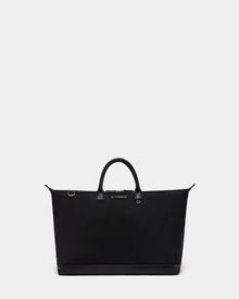 The Rudsak DUBLIN - 9324514 Black is a large unisex travel bag with two short handles and a rectangular base, shown against a plain light gray background.